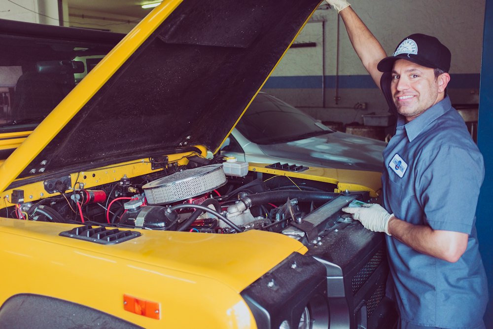 Mechanic beside a car with an open bonnet